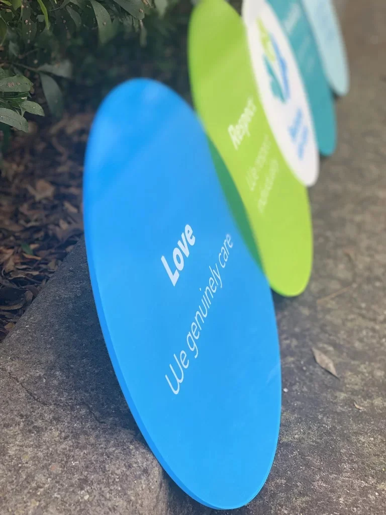 Coloured circular signage panels beside foliage