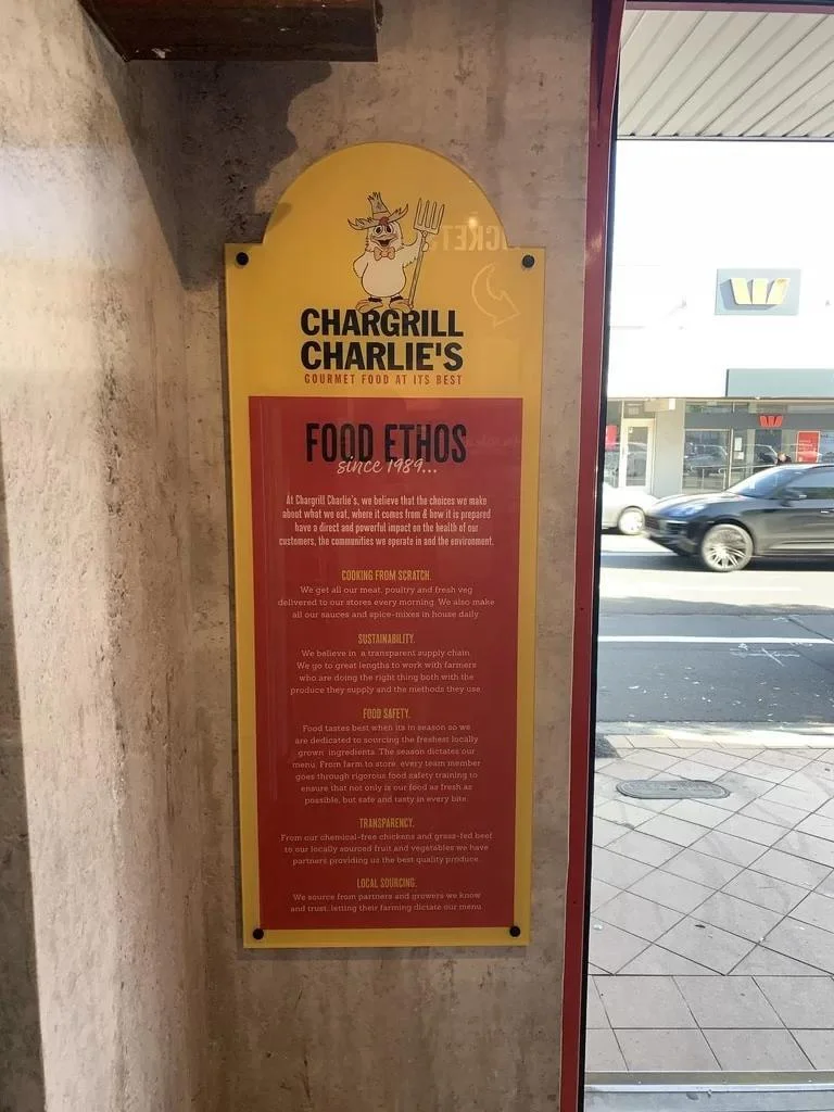 Yellow and red Chargrill Charlies sign mounted beside an entrance