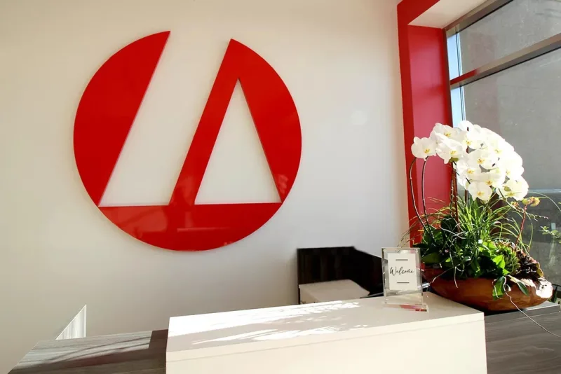 Red dimensional logo mounted above a reception desk